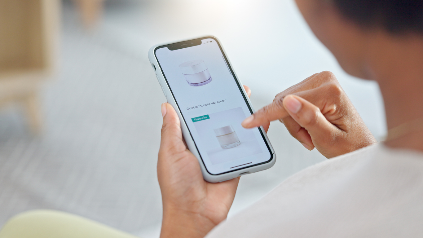 person, hands and phone in ecommerce, beauty or products on sale or discount at home. closeup of shopper looking at cosmetics, lotion or cream in online shopping on mobile smartphone app in house