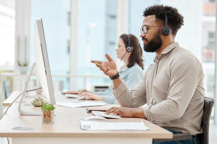 black man, customer support service office and working for online call center internet telemarketing business. crm consultant at desk, helping client and consulting computer software for advice